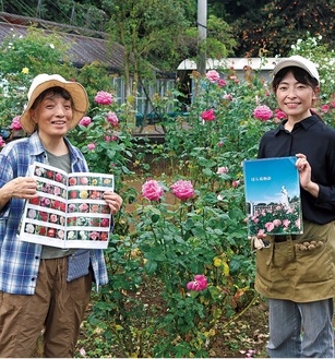 記念誌を持つ小松会長（右）と森沢さん＝ばら苑内