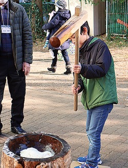 杵で餅をつく子ども