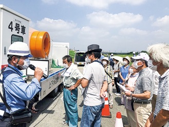 住民に排水ポンプ車の説明をする職員