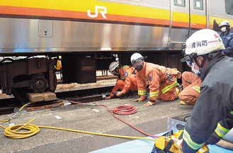 装置を使い車体を持ち上げる署員ら