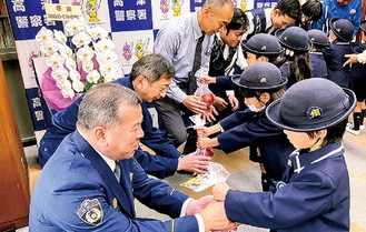 感謝の気持ちのこもったリンゴを渡す園児