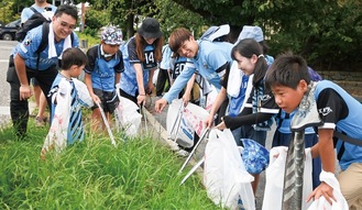 サポーターと一緒にごみ拾いをする高井選手(中央)