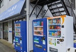 中野島・いずみ薬局の屋外に並ぶ募金自販機(右)