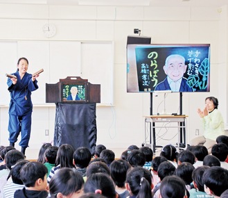 拍子木を手に紙芝居を披露する望月さん（左）と清水さん＝2月20日、菅小学校