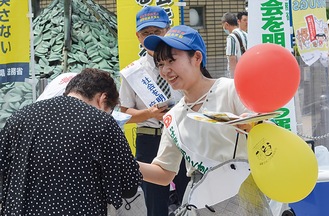 啓発グッズを配る学生