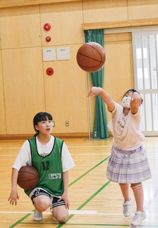 子どもにパスの仕方を教える森田さん（左）