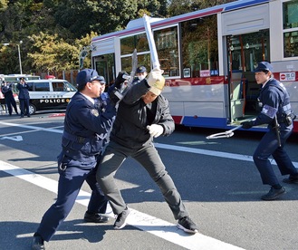 バスから降りた犯人を制圧する警察官