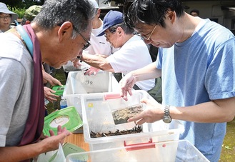 虫籠を手にスズムシを譲り受ける参加者