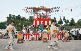 岡上小学校で２段に組まれたやぐらの周りを踊る参加者