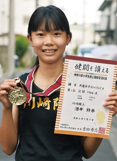 表彰状とメダルを持つ酒井鈴奈さん