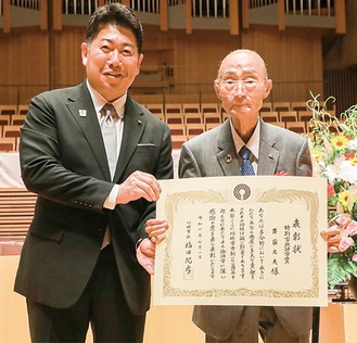 賞状を手にする斎藤さん（右）