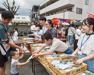 きゅうりを手配りする看護学校の学生