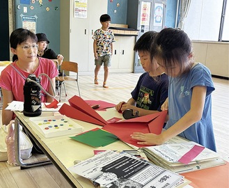 紙飛行機づくりを行う参加者