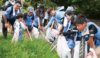 サポーターと一緒にごみ拾いをする高井選手(中央)