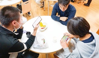 カフェでくつろぐ川崎高校の生徒たち（手前２人）