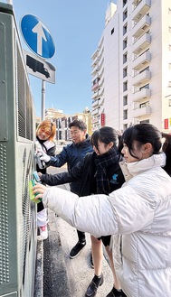 学生と一緒に落書き消しに汗を流す（左から）井上京子さんと福田市長