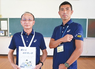 冊子を持つ小野会長（左）と同自治会ユニフォームをＰＲする小林さん