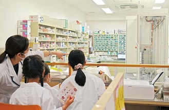 自動調剤棚を見学する子どもたち