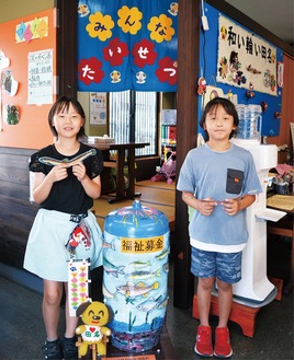 募金箱（中央）と大平侑さん（右）、島宮梨菜さん