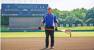 万全の状態に仕上げた球場で愛用のトンボを手にする高城さん