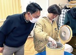 着火剤をつくる利用者とそれを見つめる網野社長