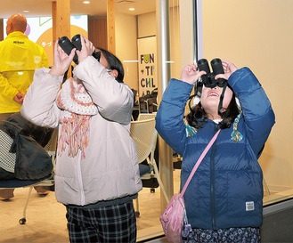 双眼鏡で空をのぞく子ども