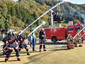 ポンプ車の上から一斉放水を指揮する高橋さん