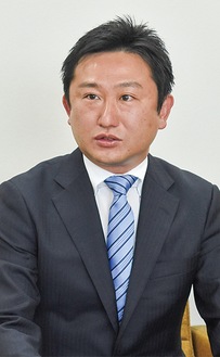 記者会見で決意を述べる滝田氏