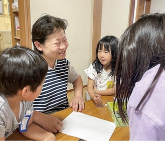 子どもたちと笑顔でふれ合う館合さん＝22日・西鶴間地域家族しんちゃんハウス