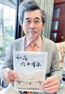 記念誌を手に取る片山会長