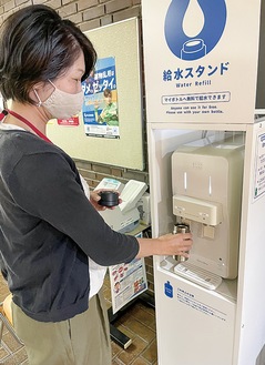 持参した水筒に常温水を入れる市職員