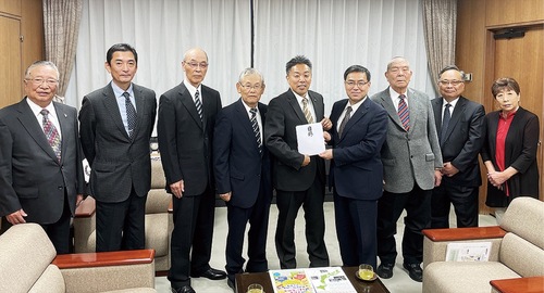 古谷田市長に目録を渡す長沢会長（右から４人目）