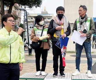 間伐材で作られた記念メダルを入賞者に贈り、参加した選手たちにあいさつする小島さん（左）