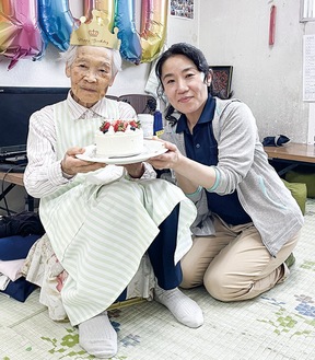 澤田理事長（右）からお祝いのケーキを受け取る久保さん