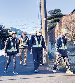 ゴミ拾い用のトングを手にしながら地域をパトロールするメンバーら