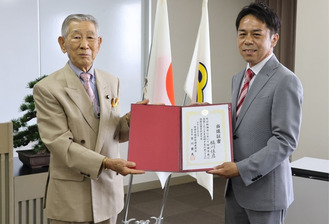 橘川氏（右）に当選証書を手渡す吉川委員長（左）