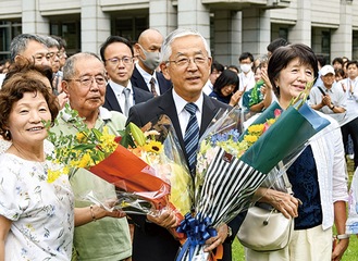 支持者から花束を受け取る古塩市長＝７月24日・綾瀬市役所