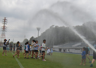 大雨のように降らせるスプリンクラーを追って参加者が動く