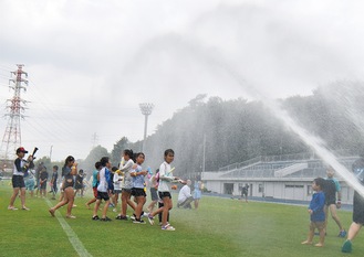 大雨のように降らせるスプリンクラーを追って参加者が動く