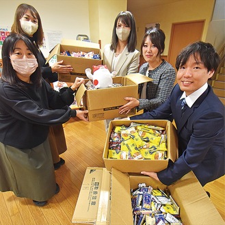 お菓子を渡す同店スタッフ（右側）