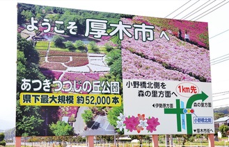 満開のツツジが目を引く大型看板