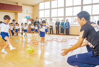 選手の指導でボールを使って運動