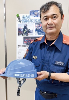 団員専用のヘルメットを紹介する職員