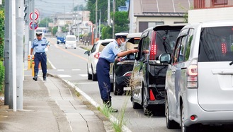 ドライバーに啓発品を手渡す交通指導隊