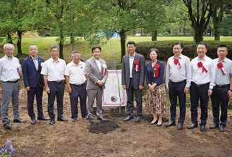 柳の木を挟んで王書記（右）と山口市長（左）