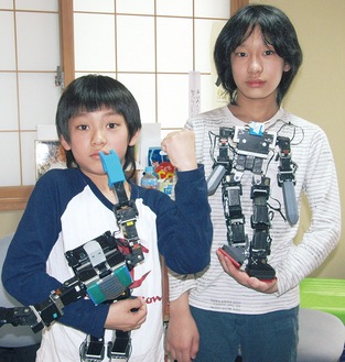 ロボットを手にする修一さん（右）と大知さん