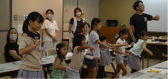 作品で遊ぶ参加者と山崎さん（写真奥）