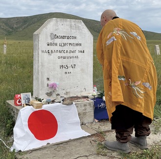 慰霊碑に言葉を掛ける塚越住職（同寺提供）