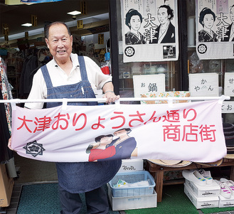 新たな名前が入ったのぼりを持ってＰＲする西村会長