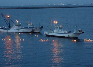 次々と海に流される灯ろう（同会提供）